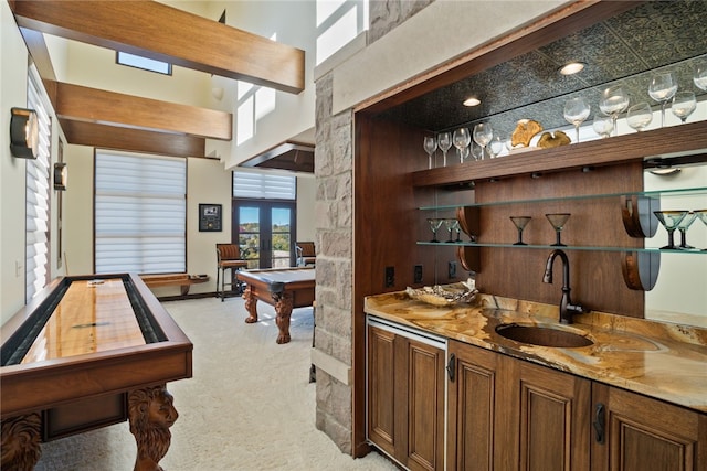 bar featuring light carpet, french doors, sink, pool table, and light stone counters