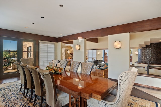 dining area with beamed ceiling and a healthy amount of sunlight