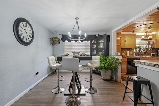 dining area featuring hardwood / wood-style floors, a chandelier, and sink