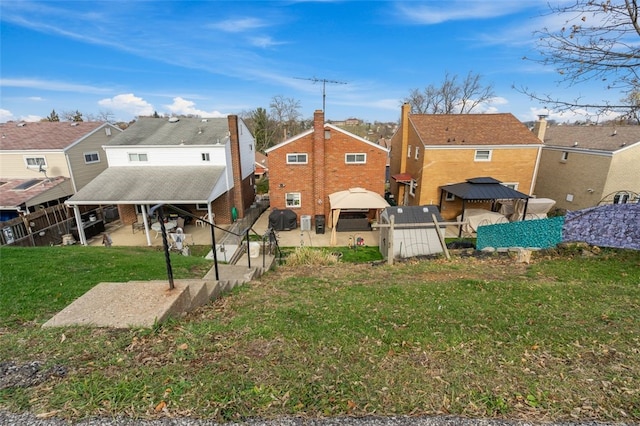 back of property with a gazebo, a patio, and a lawn