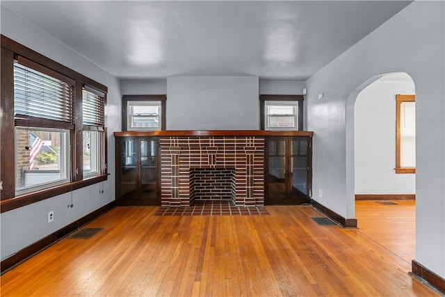 unfurnished living room featuring a fireplace and hardwood / wood-style flooring