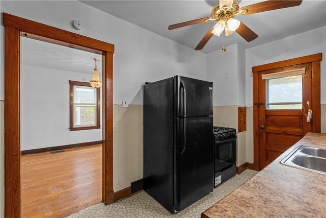 kitchen with ceiling fan, light hardwood / wood-style flooring, black appliances, and sink