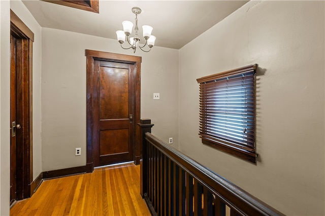 hallway featuring hardwood / wood-style floors and a notable chandelier