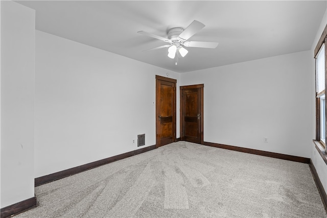 empty room with ceiling fan and carpet floors