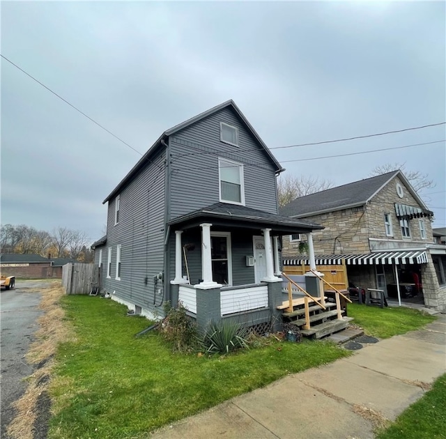 view of front facade featuring covered porch and a front yard