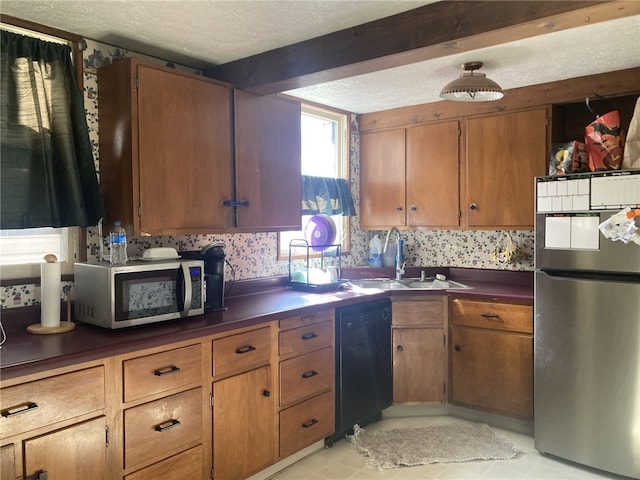 kitchen featuring a textured ceiling, sink, and appliances with stainless steel finishes