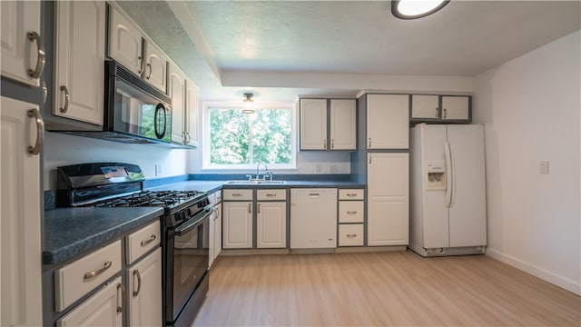 kitchen featuring sink, light hardwood / wood-style floors, and black appliances