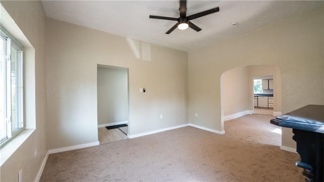 unfurnished living room featuring light carpet and ceiling fan