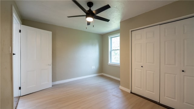 unfurnished bedroom with a closet, light hardwood / wood-style flooring, and ceiling fan