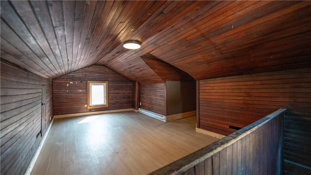 bonus room featuring light hardwood / wood-style flooring, vaulted ceiling, wooden ceiling, and wood walls