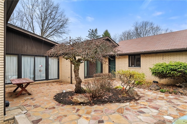 view of exterior entry with a patio