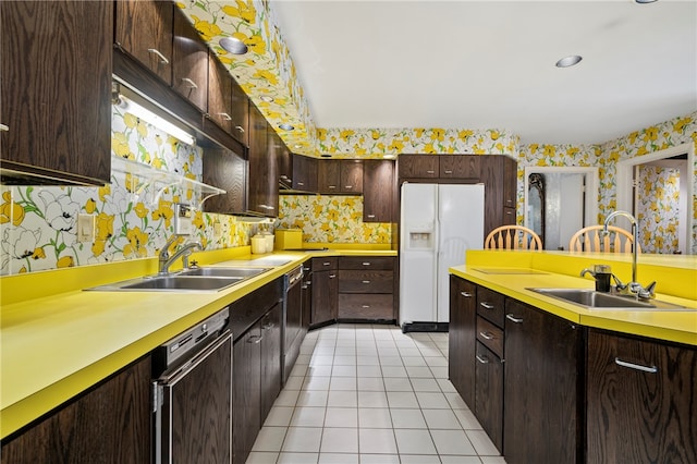 kitchen featuring dishwasher, white fridge with ice dispenser, sink, dark brown cabinets, and light tile patterned flooring