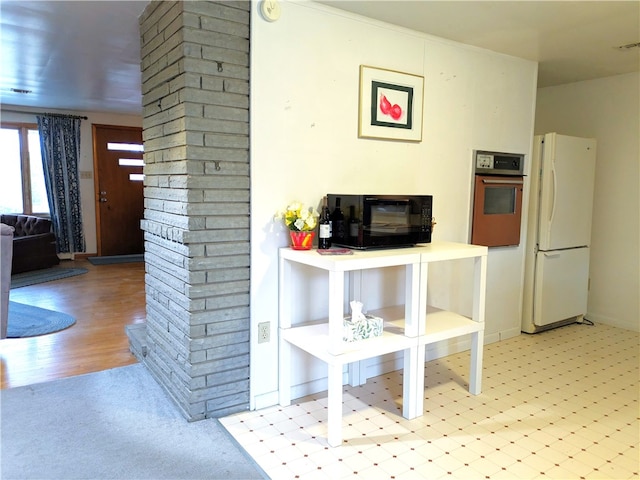 interior space featuring light wood-type flooring, white fridge, and oven