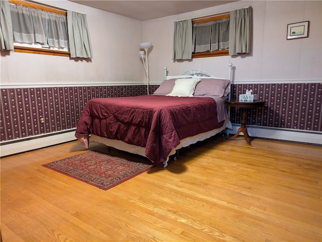 bedroom with light wood-type flooring and a baseboard radiator