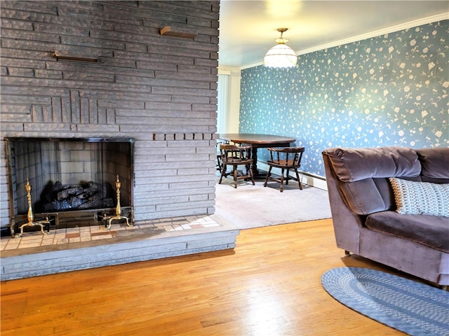 living room with baseboard heating, hardwood / wood-style floors, and ornamental molding