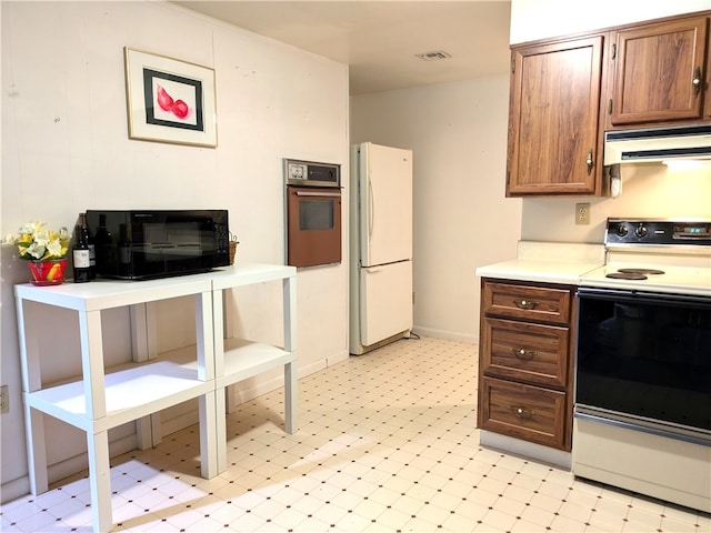 kitchen featuring white appliances and range hood