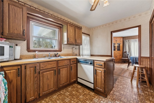 kitchen with dishwasher, sink, light hardwood / wood-style flooring, ceiling fan, and kitchen peninsula