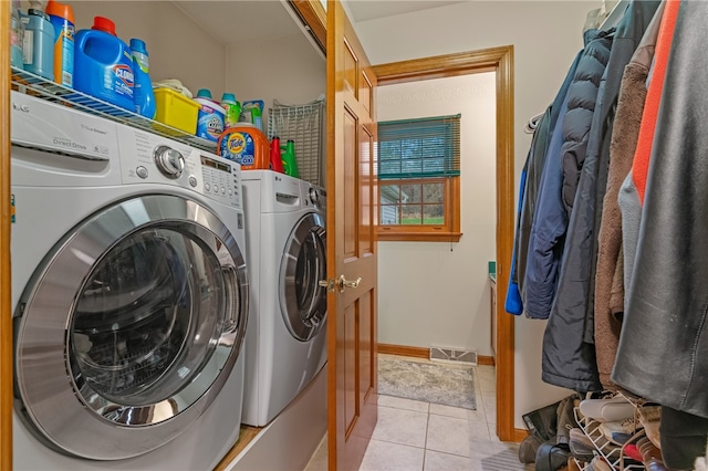 laundry area with light tile patterned floors and washing machine and clothes dryer