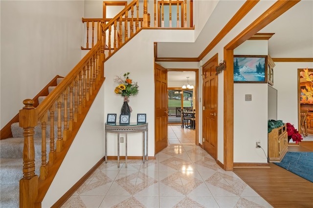 stairs featuring a notable chandelier, wood-type flooring, and crown molding