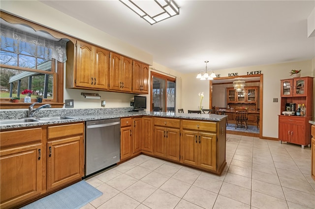 kitchen featuring kitchen peninsula, stainless steel dishwasher, sink, a notable chandelier, and hanging light fixtures