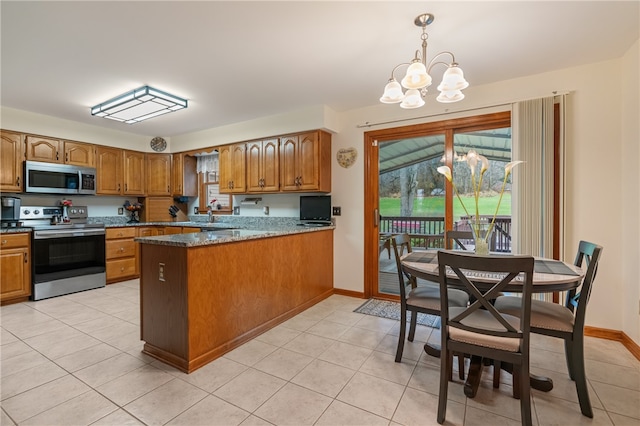 kitchen featuring pendant lighting, an inviting chandelier, stone countertops, kitchen peninsula, and stainless steel appliances