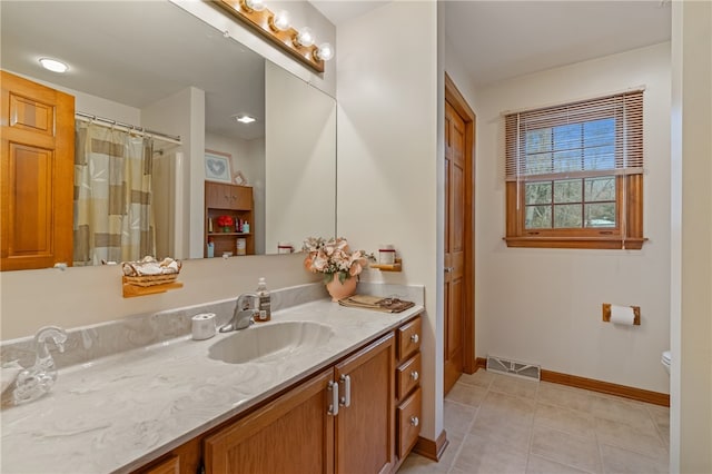 bathroom featuring tile patterned flooring, vanity, and toilet