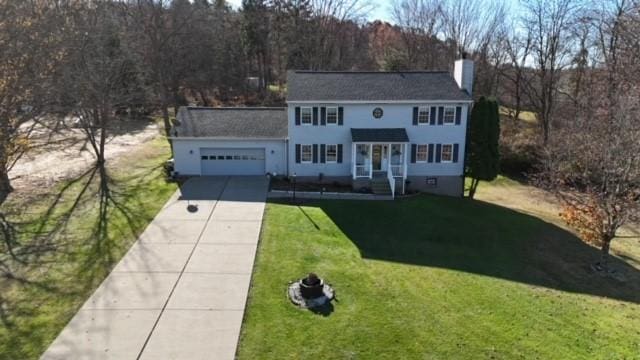104 Caromar Dr, Adams Twp, PA 16046 - colonial home with concrete driveway, a garage, a chimney, and a front lawn