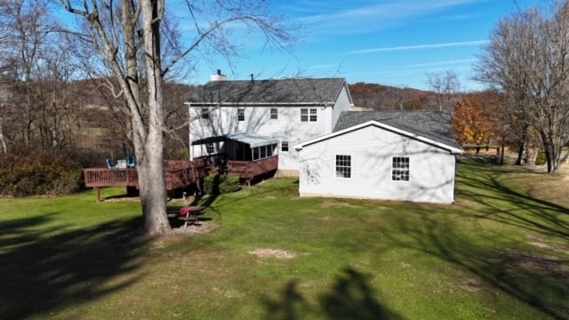 back of property featuring a yard and a wooden deck