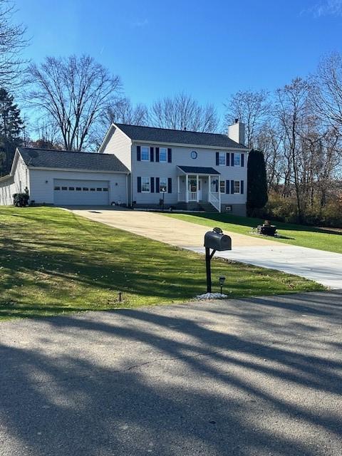104 Caromar Dr, Adams Twp, PA 16046 - colonial inspired home featuring concrete driveway, a chimney, a garage, and a front lawn