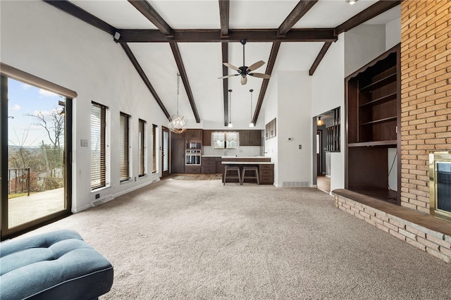 living room featuring beam ceiling, light colored carpet, high vaulted ceiling, and a brick fireplace