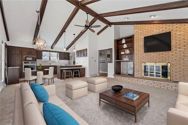 living room featuring a fireplace, beam ceiling, light colored carpet, and high vaulted ceiling