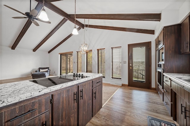 kitchen with hanging light fixtures, beamed ceiling, black electric cooktop, ceiling fan with notable chandelier, and light wood-type flooring