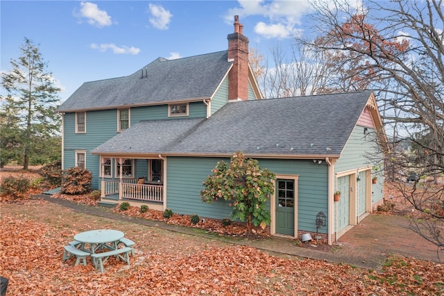 back of property featuring covered porch and a garage