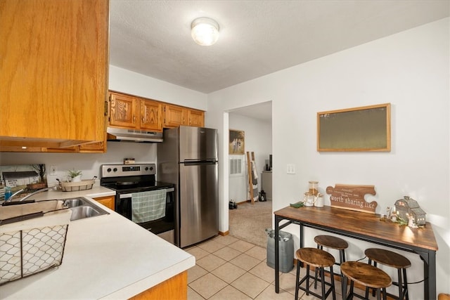 kitchen featuring light tile patterned flooring, appliances with stainless steel finishes, a textured ceiling, and sink