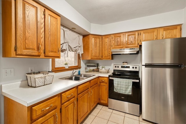 kitchen featuring a textured ceiling, light tile patterned flooring, sink, and appliances with stainless steel finishes