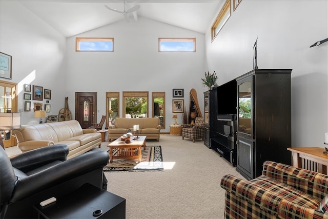 carpeted living room with ceiling fan and high vaulted ceiling