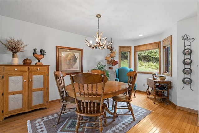 dining space with a chandelier and light hardwood / wood-style floors