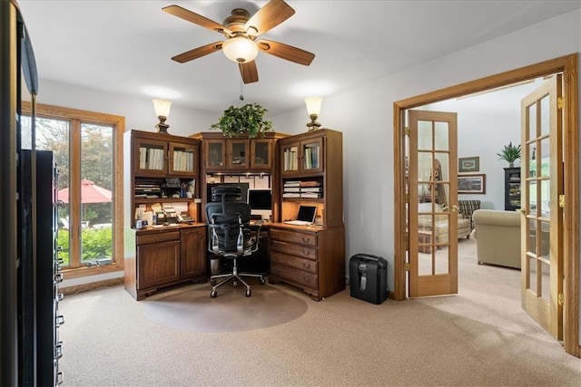 carpeted home office with ceiling fan and french doors