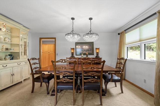 carpeted dining space featuring an inviting chandelier