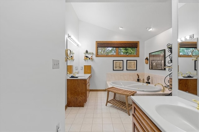 bathroom featuring tile patterned floors, vanity, lofted ceiling, and a tub