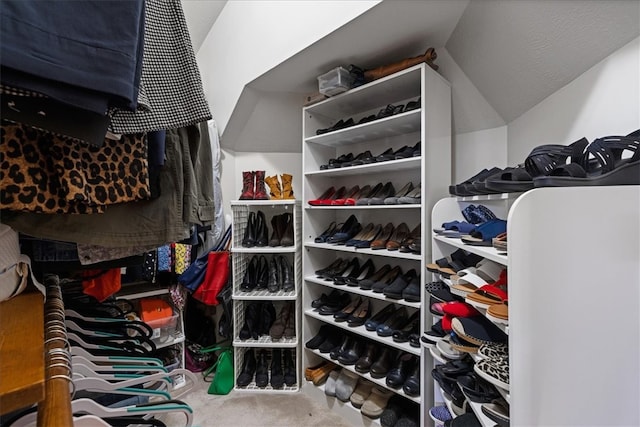 walk in closet with carpet flooring and lofted ceiling