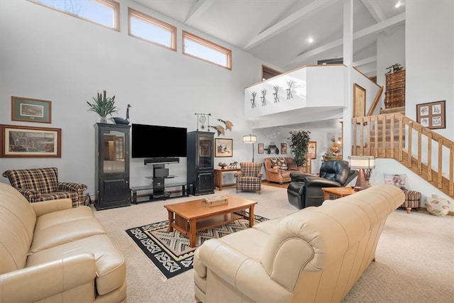 living room with beam ceiling, a towering ceiling, and light carpet