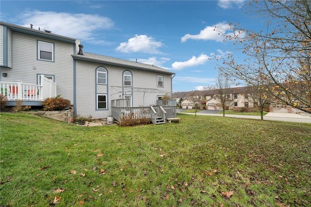 rear view of house featuring a yard and a deck