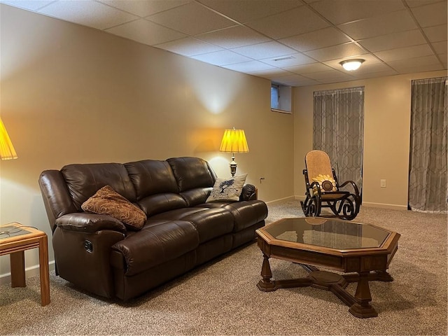 carpeted living room with a paneled ceiling