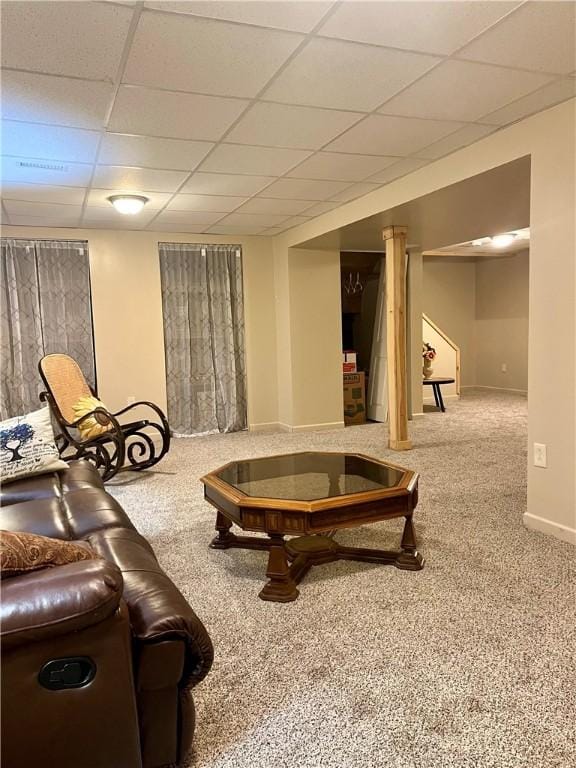 living room featuring carpet flooring and a drop ceiling