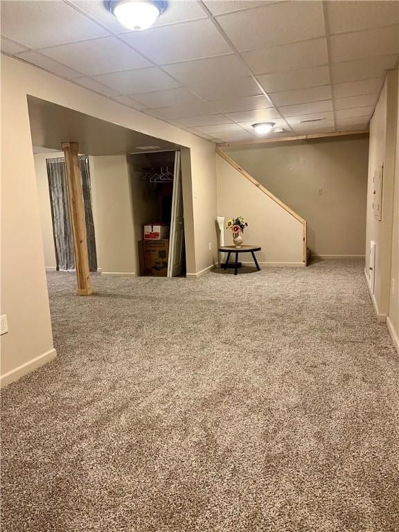 basement with carpet and a paneled ceiling