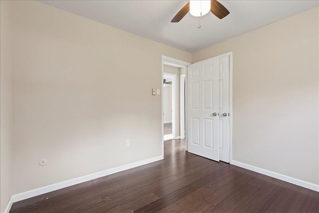 empty room with dark hardwood / wood-style flooring and ceiling fan