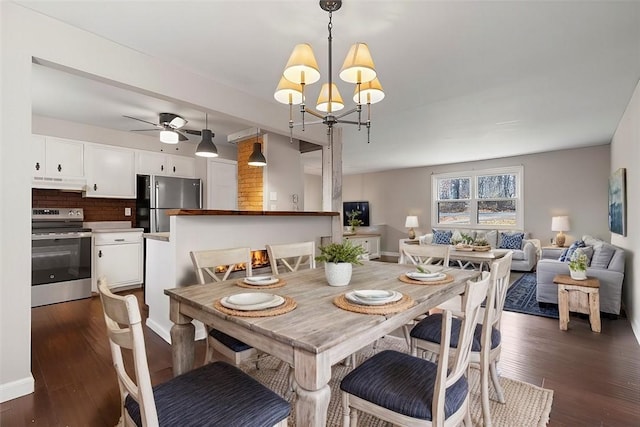 dining space with dark wood-type flooring and ceiling fan with notable chandelier