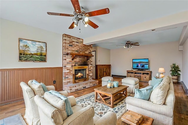 living room with ceiling fan, light wood-type flooring, and a fireplace