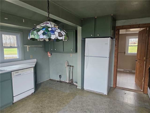 kitchen featuring white appliances, decorative light fixtures, and green cabinets